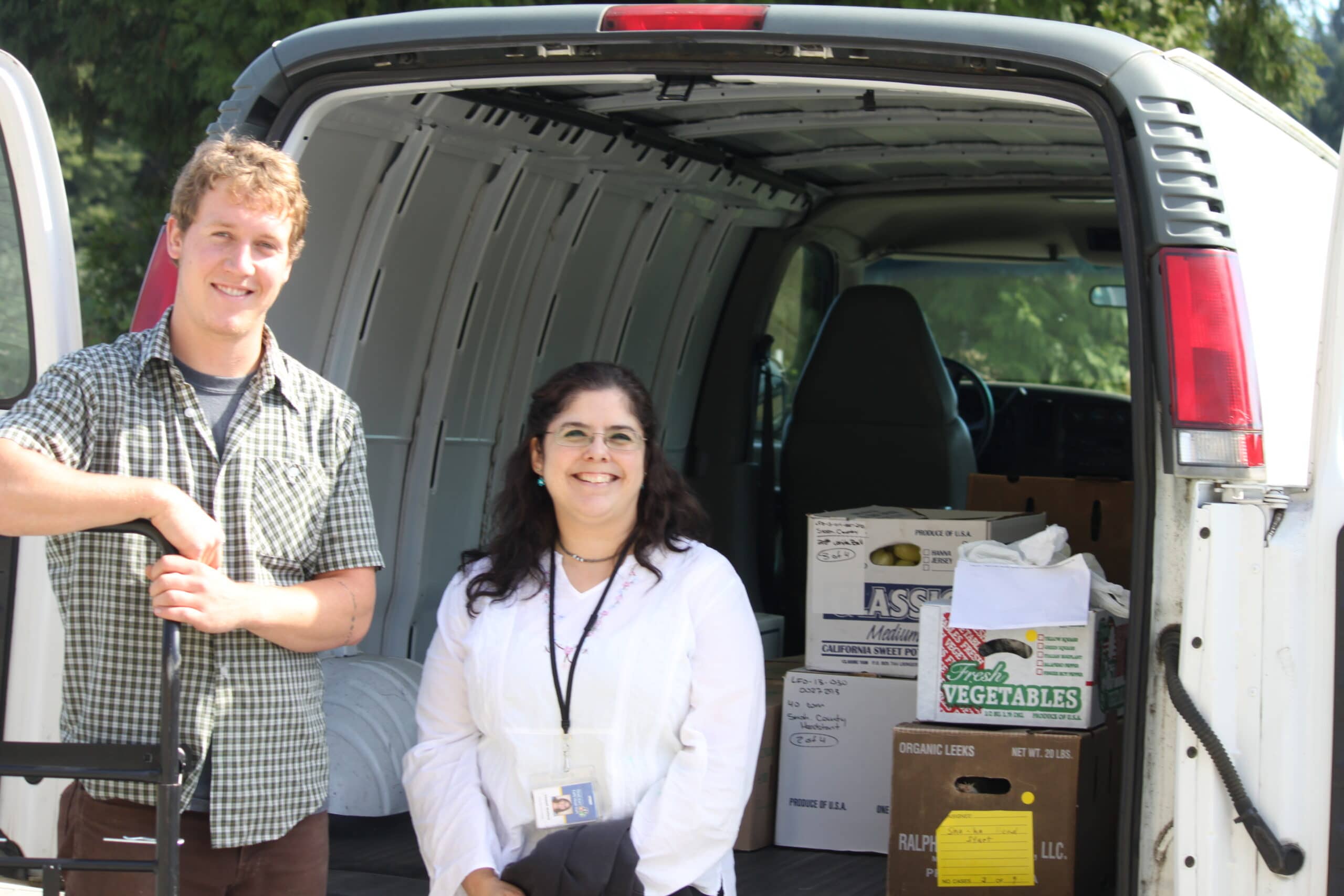 Austin, Food Hub Coordinator, and Chantal, child care food service director, pause for a moment while loading food for the kids' cafeteria.