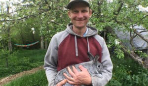 Daniel from Hawthorn Farm holds homesteaded and hand-raised rabbits.