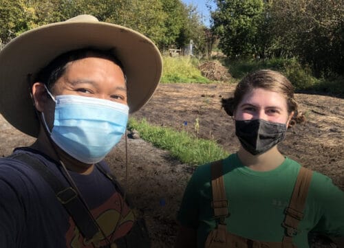 Volunteer Danno Tabing and staff member Angelica Lucchetto stop for a masked selfie during a sunny day in August.