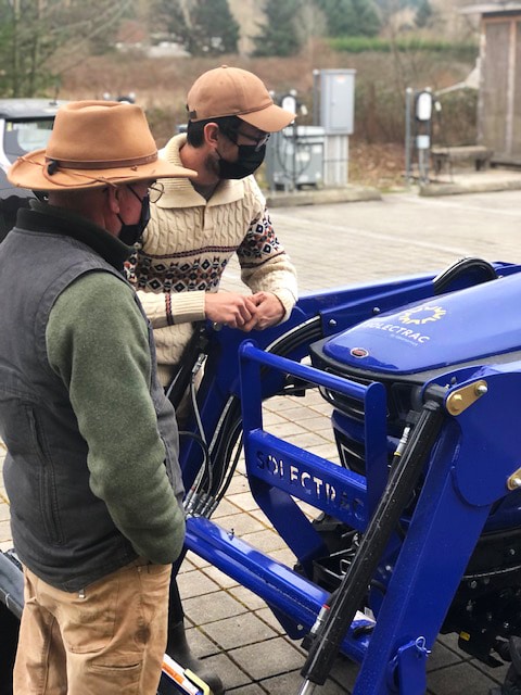 Farmers inspect the electric tractor purchased through funds through King Conservation District.