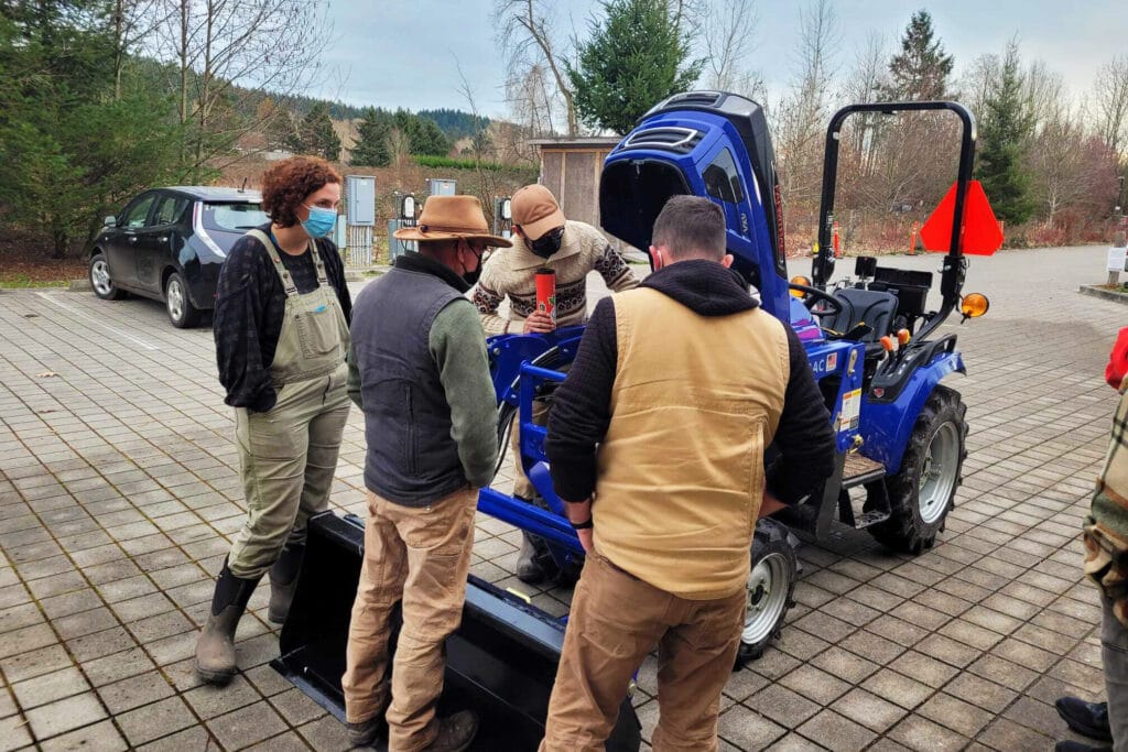 Farmers of the Sustainable Ag Tool Share in the Sammamish Valley inspect the new Solectrac electric tractor.