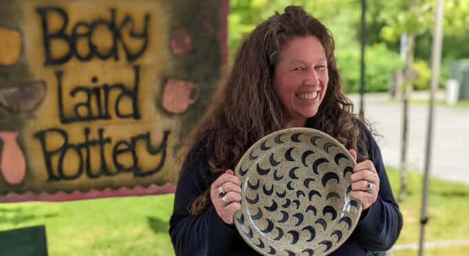 Potter Becky Laird holds one of her large handmade ceramic bowls at the 21 Acres Farm Market.