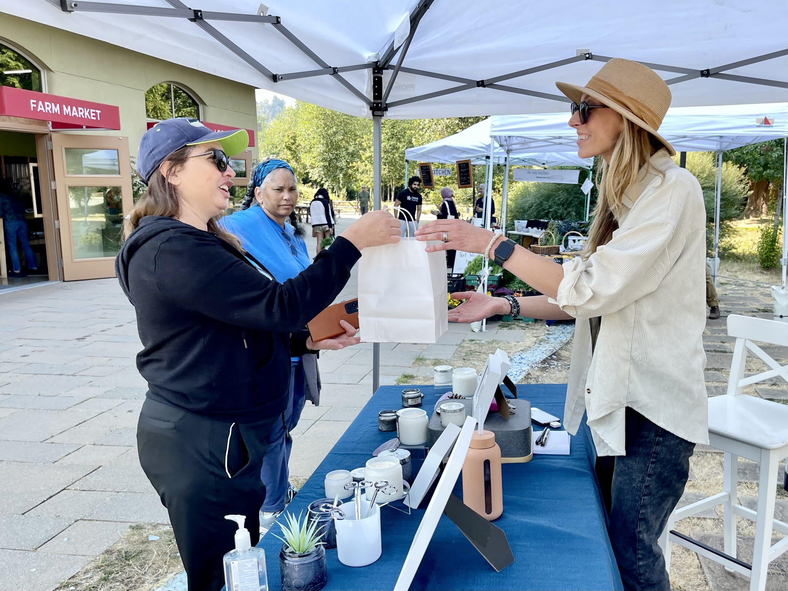 A visitor makes a purchase at a 21 Acres popup market.