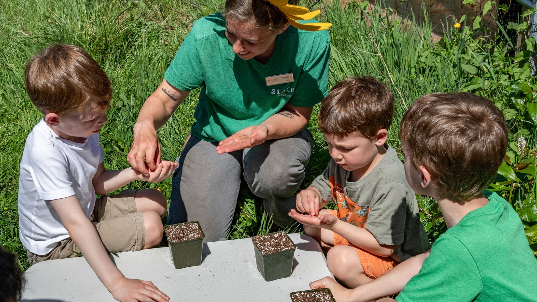 Kids and staff planting seeds at 21 Acres.