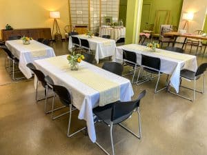 The downstairs meeting room set up with tables and chairs for a meeting.